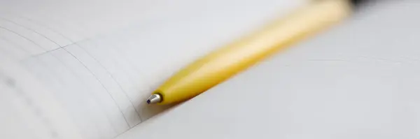 Caneta esferográfica amarela deitada no notebook close-up — Fotografia de Stock