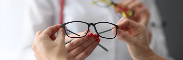 Oftalmolog erbjuder patientglasögon för vision i kliniken närbild — Stockfoto