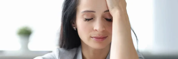 Mulher cansada sentada à mesa com os olhos fechados — Fotografia de Stock