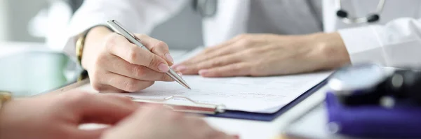 Médico aconselhando paciente e escrevendo em documentos close-up — Fotografia de Stock