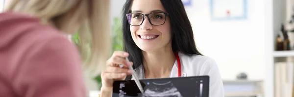 Ginekolog pokazujący pacjentowi USG płodu w tabletkach — Zdjęcie stockowe