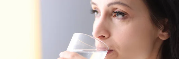 Jeune femme tenant du verre dans ses mains et de l'eau potable de celui-ci — Photo