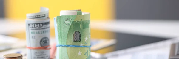 Rolled δολάρια χαρτί και ευρώ και κέρματα που βρίσκονται σε closeup τραπέζι — Φωτογραφία Αρχείου