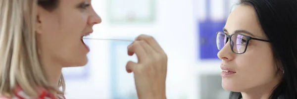 Толаринголог осматривает пациентов вблизи горла — стоковое фото