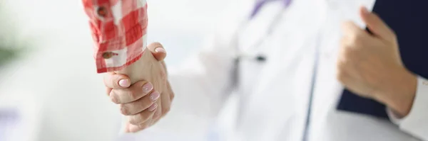 Doutor segura prancheta aperta as mãos com paciente — Fotografia de Stock