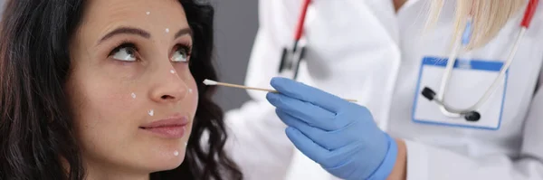 Dermatoloog brengt witte crème op patiënten gezicht — Stockfoto