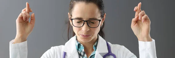 Arzt mit geschlossenen Augen drückt Daumen — Stockfoto