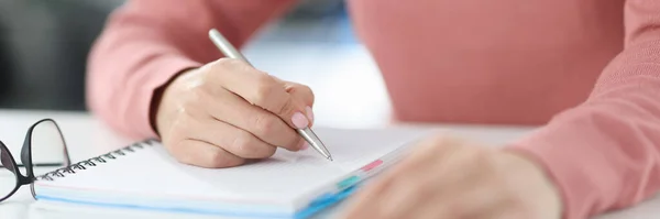 Mujer sostiene pluma en sus manos y toma notas en el diario —  Fotos de Stock