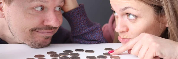 Άντρας και γυναίκα κοιτάζουν τα νομίσματα με απογοήτευση. — Φωτογραφία Αρχείου