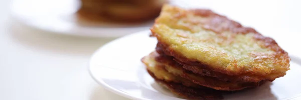 Aardappel latkes liggend op witte plaat in cafe closeup — Stockfoto