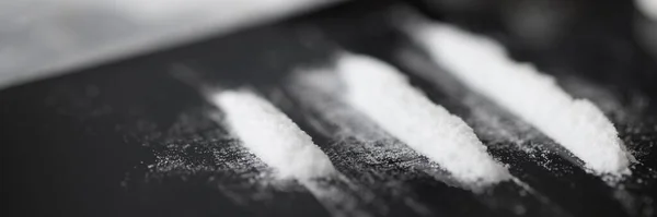 Closeup of white narcotic powder tracks on black background — Stock Photo, Image