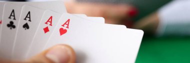 Pokerde kazanan eli yakın planda tutan adam.