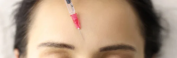 Cosmetische injectie wordt gegeven aan het voorhoofd van jonge vrouw close-up — Stockfoto