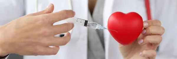 Doctor injecting medicine into red toy heart closeup — Stock Photo, Image