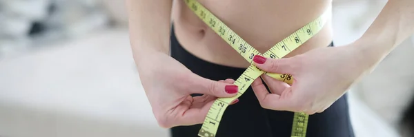 Mulher medindo sua cintura com fita de centímetros em casa — Fotografia de Stock