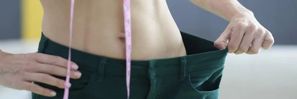 Vrouw toont resultaten van het verliezen van gewicht in taille — Stockfoto