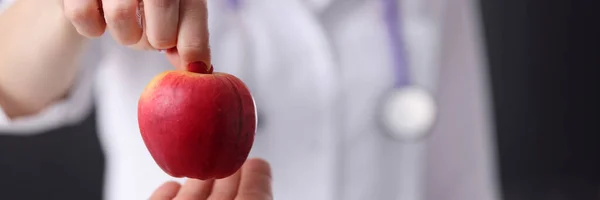 医生把一个成熟的苹果交给病人.抗衰老治疗 — 图库照片