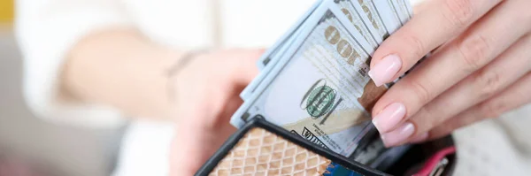 Kobieta wyciąga amerykańskie banknoty z portfela. — Zdjęcie stockowe