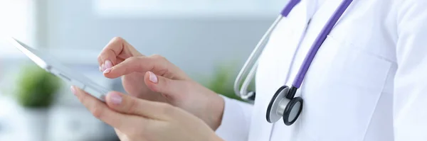 Läkare med stetoskop arbetar på digital tablett närbild — Stockfoto