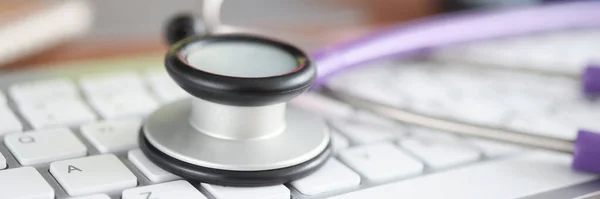 Stethoscope lying on computer keyboard in office closeup — Stock Photo, Image