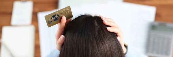 Kobieta z kartą kredytową w rękach trzyma widok z góry głowy — Zdjęcie stockowe