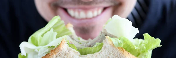 Άντρας κρατώντας σάντουιτς στα χέρια και χαμογελώντας closeup — Φωτογραφία Αρχείου