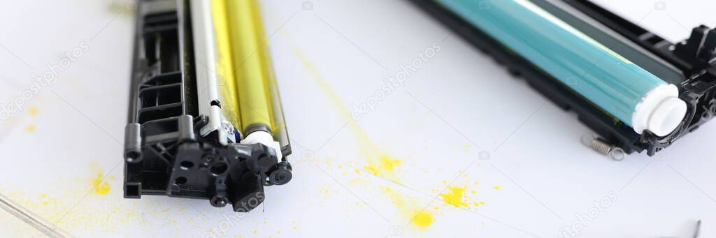 Yellow and blue cartridges for printer lying on table closeup