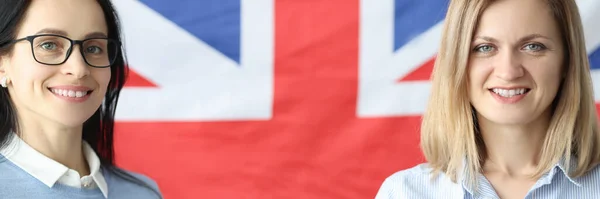 Twee lachende vrouwen staan met schriften voor de Britse vlag — Stockfoto