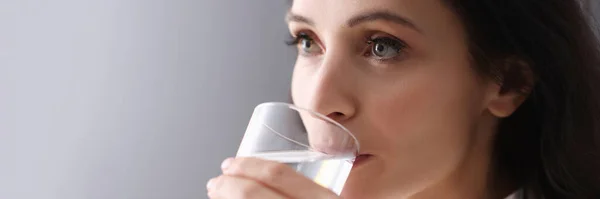 Jeune femme brune boire de l'eau du verre — Photo