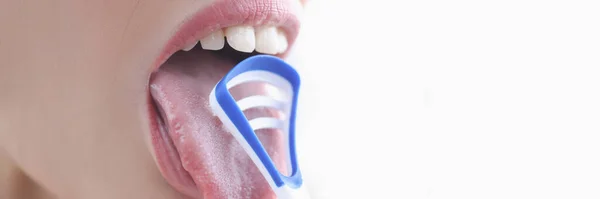 Young woman cleaning her tongue with scraper closeup — Stock Photo, Image