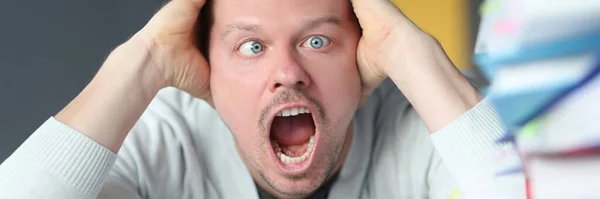 Retrato del hombre asustado que grita a la vista de carpetas con documentos — Foto de Stock