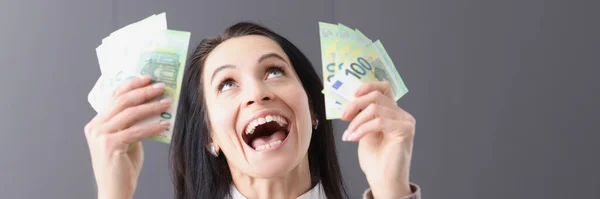 Retrato de una mujer alegre que sostiene billetes en sus manos — Foto de Stock