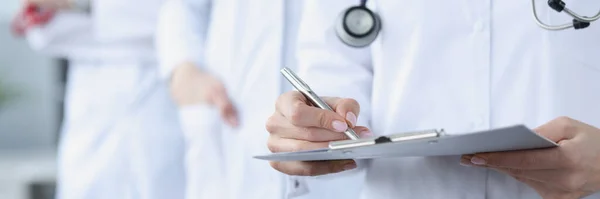 Doctors in white medical coats stand together — Stock Photo, Image