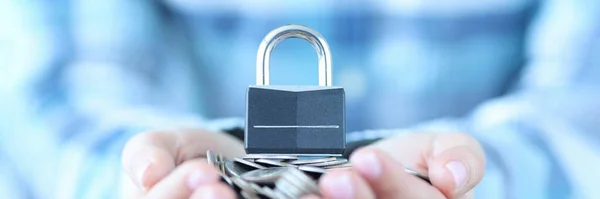 Female hand holding bunch of coins and padlock closeup