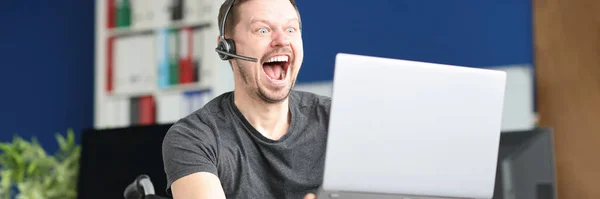 Emocionalmente alegre hombre discapacitado streamer mira en el monitor del ordenador portátil —  Fotos de Stock