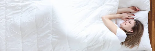 Kvinna liggande i sängen och leende ovanifrån — Stockfoto