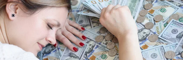 Mujer con dinero en sus manos durmiendo en billetes de dólar —  Fotos de Stock
