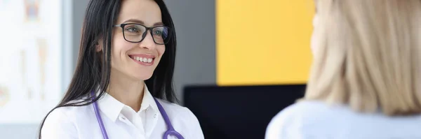 Woman doctor communicating with patient in clinic — Stockfoto