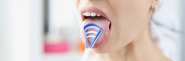 Woman cleans her tongue with special scraper — Stock Photo, Image