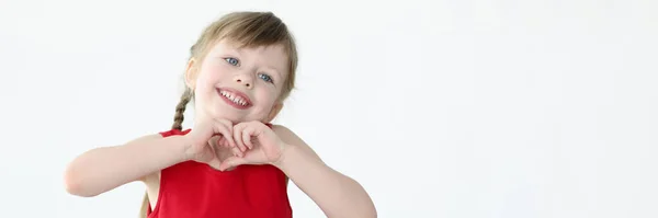 Bambina mostrando la forma del cuore con le mani — Foto Stock