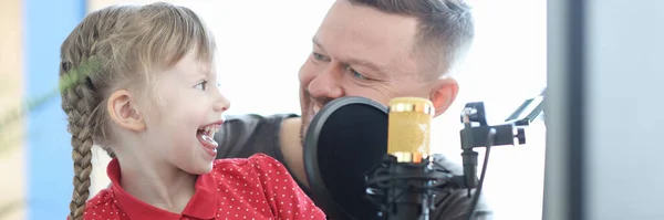 Man and girl are recording song on microphone — Stockfoto