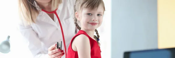 Pediatrician doctor listens to lungs of girl with stethoscope — Φωτογραφία Αρχείου
