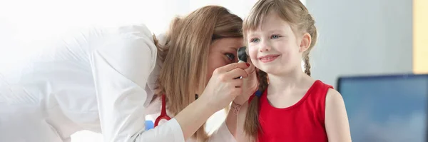 An otorhinolaryngologist examines the ear of little girl — Zdjęcie stockowe