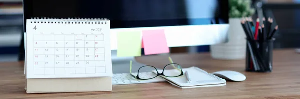 Loose foglio di carta calendario in piedi vicino al computer sul desktop primo piano — Foto Stock