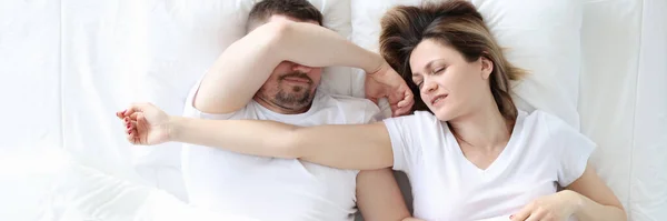 Joven hombre y mujer están durmiendo en la cama blanca grande —  Fotos de Stock