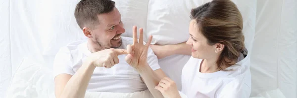 Hombre muestra mujer gestos íntimos en la cama —  Fotos de Stock