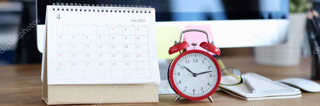 Calendar for April 2021 is on desktop next to alarm clock