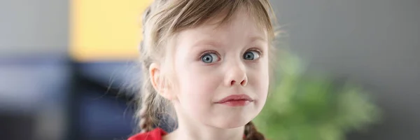 Portret van klein verdrietig meisje in rode jurk — Stockfoto