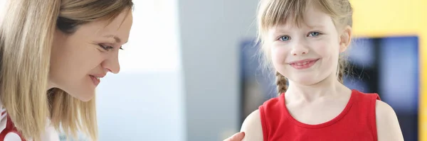 Врач-педиатр прививает маленькую девочку в плечо — стоковое фото