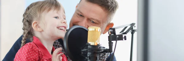 Man och flicka spelar in sin röst på mikrofon — Stockfoto